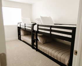 Bedroom featuring light carpet and baseboards