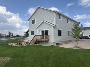 Rear view of property with a yard and a deck