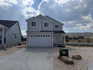 View of front of house featuring a garage, covered porch, and driveway
