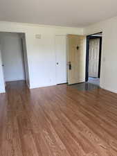 Unfurnished living room with ornamental molding and wood finished floors