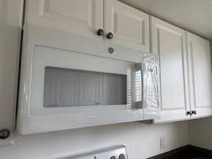 Kitchen view of white microwave and white cabinetry