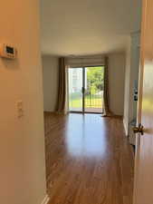 Unfurnished room with wood finished floors and a textured wall