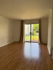 Spare room with wood finished floors and ornamental molding