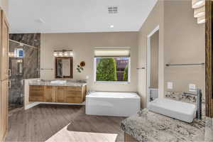 Bathroom with a stall shower, vanity, a soaking tub, light wood-style flooring, and recessed lighting