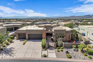Southwest-style home featuring a gate, stucco siding, a residential view, concrete driveway, and a fenced front yard
