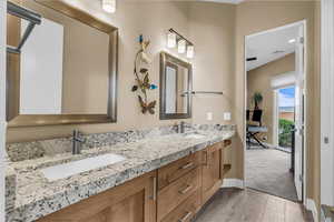 Bathroom with light wood finished floors and double vanity