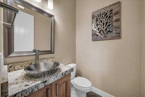 Half bathroom with vanity and toilet