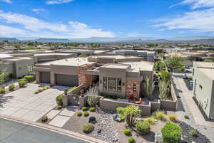 View of front of property featuring a residential view, stucco siding, a fenced front yard, driveway, and stone siding
