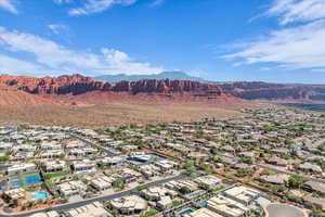 Aerial view of property and surrounding area featuring mountains and nearby suburban area