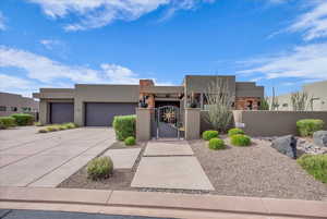 Adobe home with a gate, stucco siding, a fenced front yard, concrete driveway, and a garage