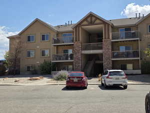 View of apartment building / complex with stairway and uncovered parking