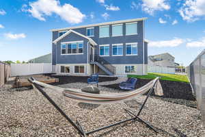 Back of house featuring stairs, stucco siding, a fenced backyard, a patio, and a fire pit