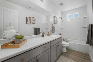 Bathroom featuring  shower combination, vanity, and light wood-style flooring