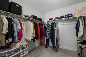 Walk in closet featuring light colored carpet