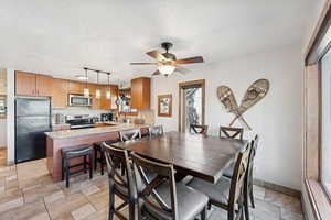 Dining area featuring a textured ceiling and a ceiling fan