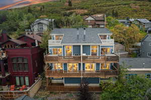 Rear view of property with a chimney and roof with shingles