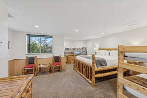 Bedroom with carpet flooring, a wainscoted wall, wood walls, and recessed lighting