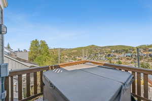 Wooden terrace with a hot tub and a mountain view