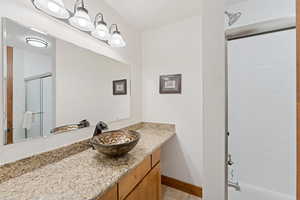 Bathroom with vanity, shower / bath combination with glass door, and light tile patterned floors