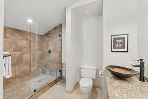 Bathroom featuring walk in shower, light tile patterned flooring, vanity, and recessed lighting