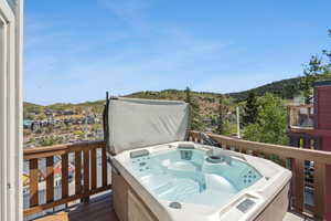 Wooden deck featuring a hot tub and a mountain view