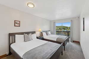Carpeted bedroom featuring access to outside and a textured ceiling