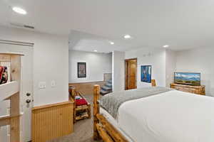 Bedroom featuring carpet floors, a wainscoted wall, wood walls, and recessed lighting