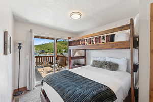 Carpeted bedroom with access to exterior and a textured ceiling