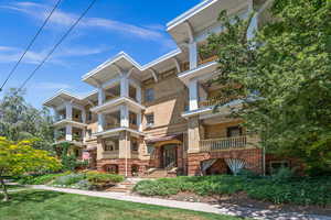 View of front of property featuring a balcony and brick siding