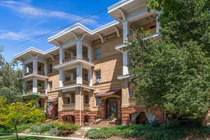 View of front of house with brick siding and a balcony