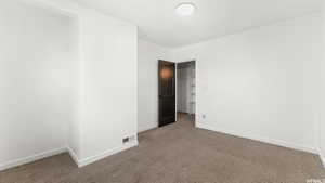 Carpeted spare room featuring baseboards