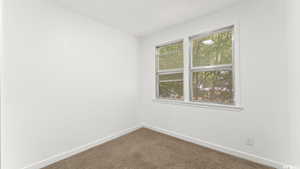 Spare room with carpet and baseboards
