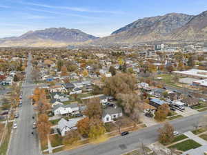 Aerial view of property and surrounding area with mountains and nearby suburban area