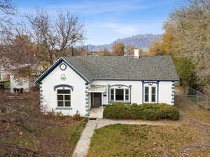 View of front of house featuring roof with shingles, a mountain view, stucco siding, and a chimney