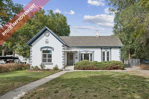View of front of house with roof with shingles, a chimney, stucco siding, and a gate