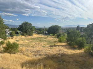 View of undeveloped land featuring a mountain backdrop and rural landscape