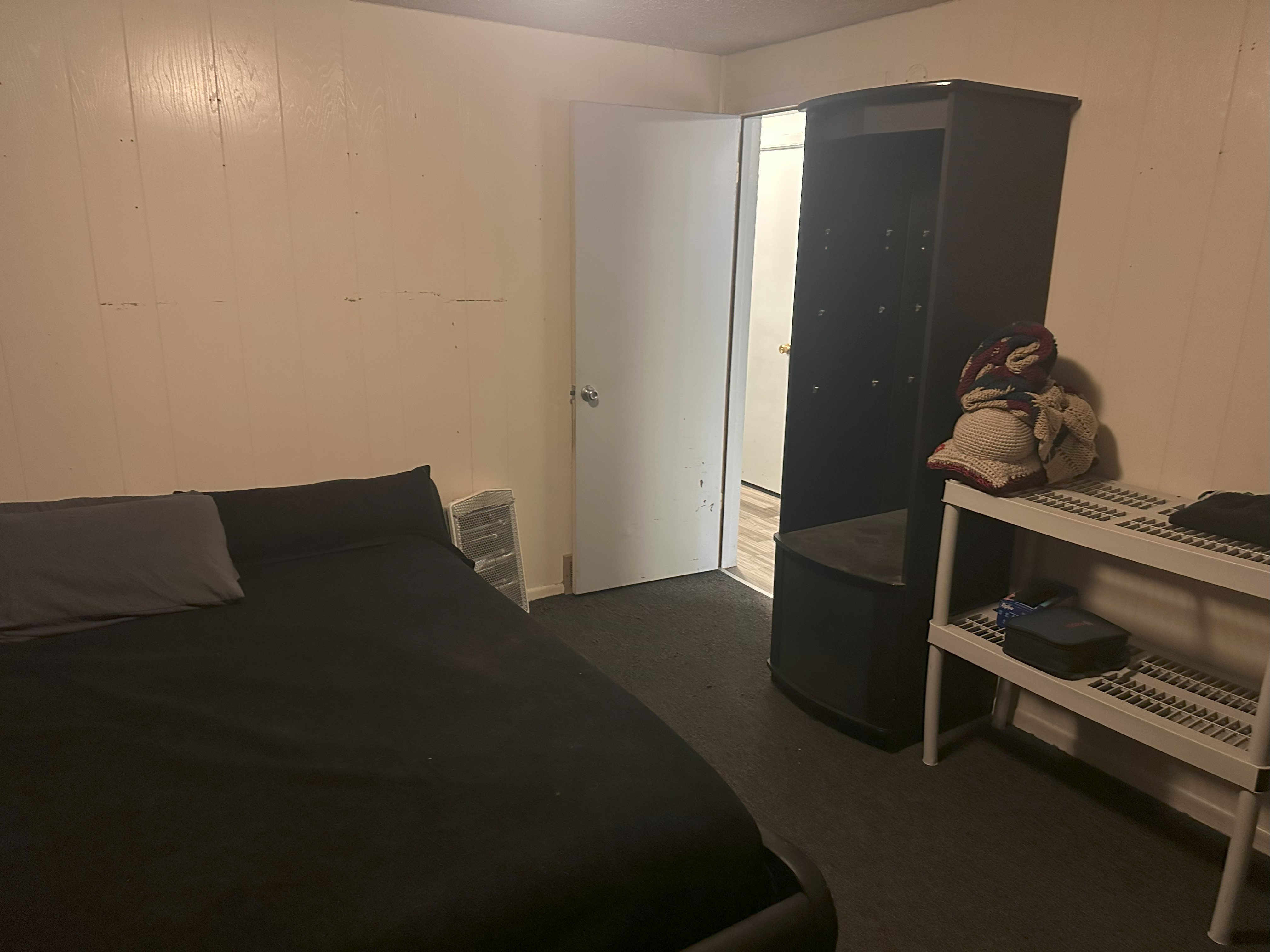 Bedroom with wooden walls and dark carpet