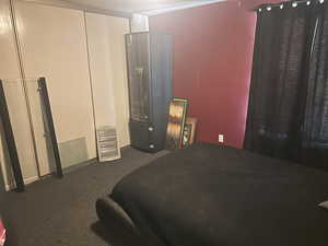 Bedroom featuring dark carpet and a textured ceiling