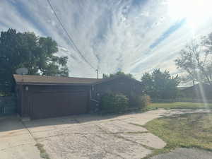 View of side of home featuring concrete driveway, a garage, and board and batten siding