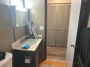 Half bath with vanity and light wood-style floors