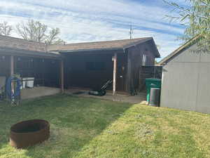 Back of property with a lawn and a shingled roof