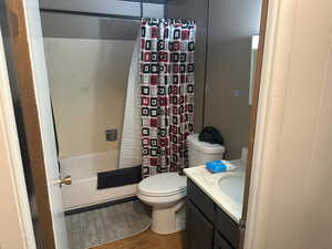 Bathroom featuring vanity, wood finished floors, and shower / tub combo with curtain