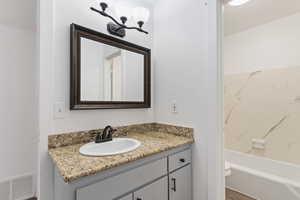 Bathroom with vanity, a chandelier, and shower / bathtub combination
