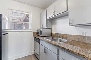 Kitchen featuring appliances with stainless steel finishes, gray cabinetry, and light wood-style floors