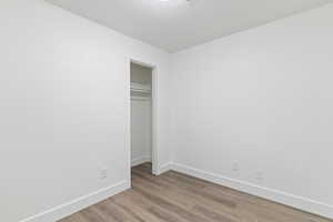 Unfurnished bedroom featuring light wood-style flooring and a closet