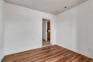 Empty room with a textured ceiling and wood finished floors