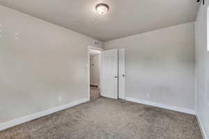 Unfurnished room featuring carpet and baseboards