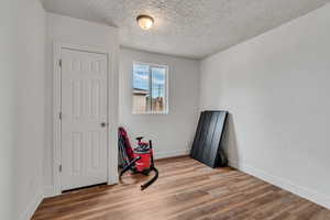 Unfurnished bedroom with wood finished floors and a textured ceiling
