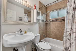 Bathroom with a textured wall and shower / tub combo