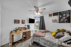 Carpeted bedroom featuring a textured ceiling and a ceiling fan
